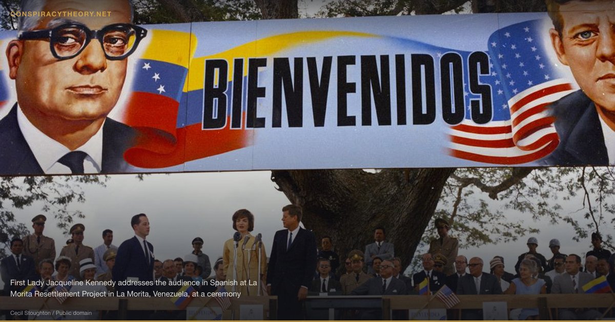 Bay of Pigs — CIA Betrayal of Kennedy (1961) — First Lady Jacqueline Kennedy addresses the audience in Spanish at La Morita Resettlement Project in La Morita, Venezuela, at a ceremony granting farmers titles to land under the Agrarian Reform Program. President John F. Kennedy stands to the right of Mrs. Kennedy; President of Venezuela Rómulo Betancourt sits to the right of President Kennedy in the front row. US State Department interpreter, Donald Barnes, stands to the left of Mrs. Kennedy. Also seated in the group at right: United States Chief of Protocol, Angier Biddle Duke; Chester B. Bowles, President Kennedy's Special Representative and Adviser on African, Asian, and Latin-American Affairs; US Ambassador to Venezuela, Teodoro Moscoso; Assistant Secretary of State for Inter-American Affairs, Robert F. Woodward; Naval Aide to President Kennedy, Captain Tazewell Shepard.